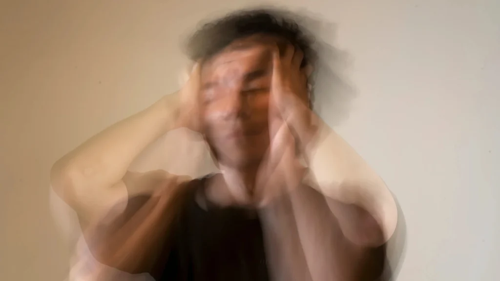 A-blurred-image-of-a-man-holding-his-head-symbolizing-emotional-distress-and-social-anxiety
