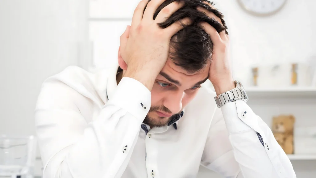 A-man-holding-his-head-in-his-hands-showing-stress-and-frustration-representing-the-silent-struggle-of-mental-health-challenges