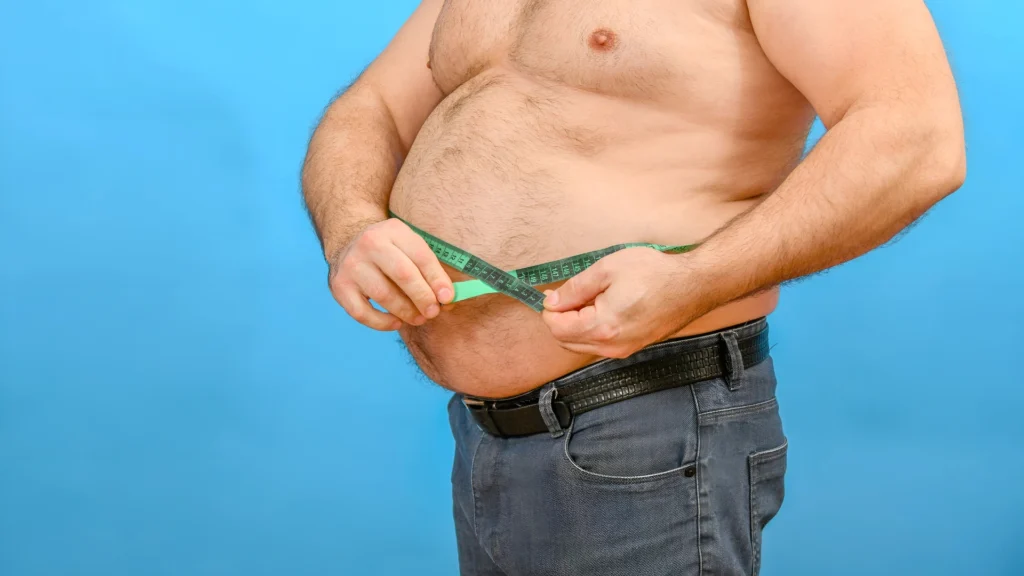 A-man-measuring-his-waistline-depicts-the-Challenges-of-Mental-Health-and-Obesity-and-their-impact-on-well-being