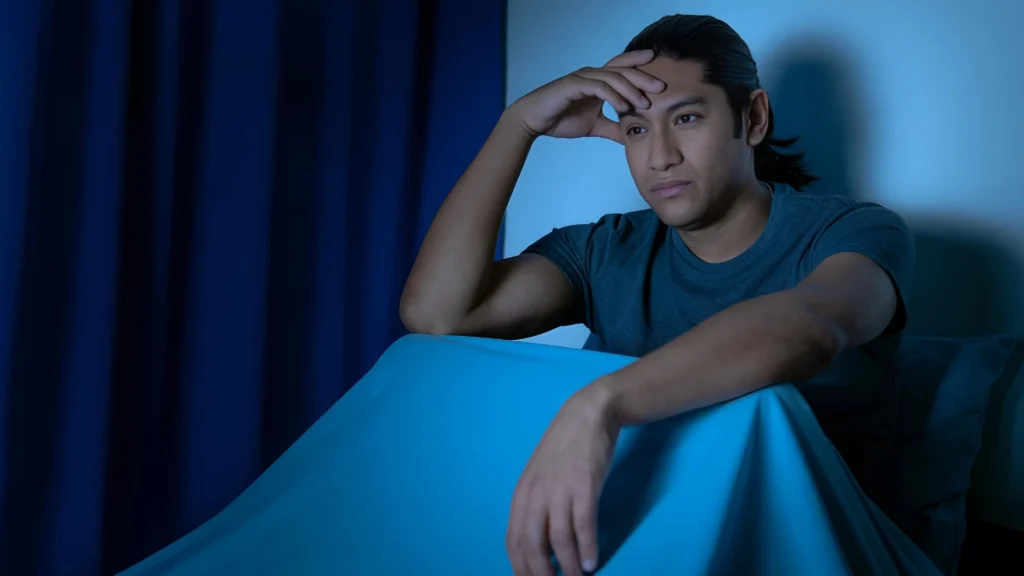 A-man-sitting-in-bed-at-night-depicts-the-Challenges-of-Mental-Health-and-its-impact-on-well-being