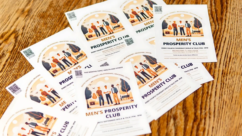 Flyers-for-Mens-Prosperity-Club-spread-on-a-wooden-table