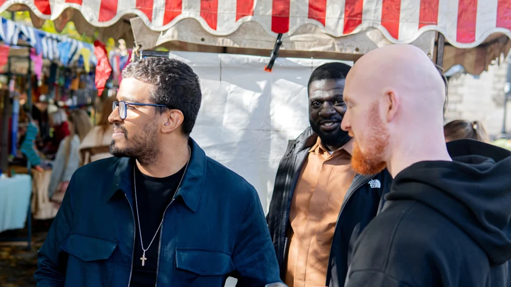 a-MPC-group-talking-in-front-of-market-stalls-with-striped-canopies
