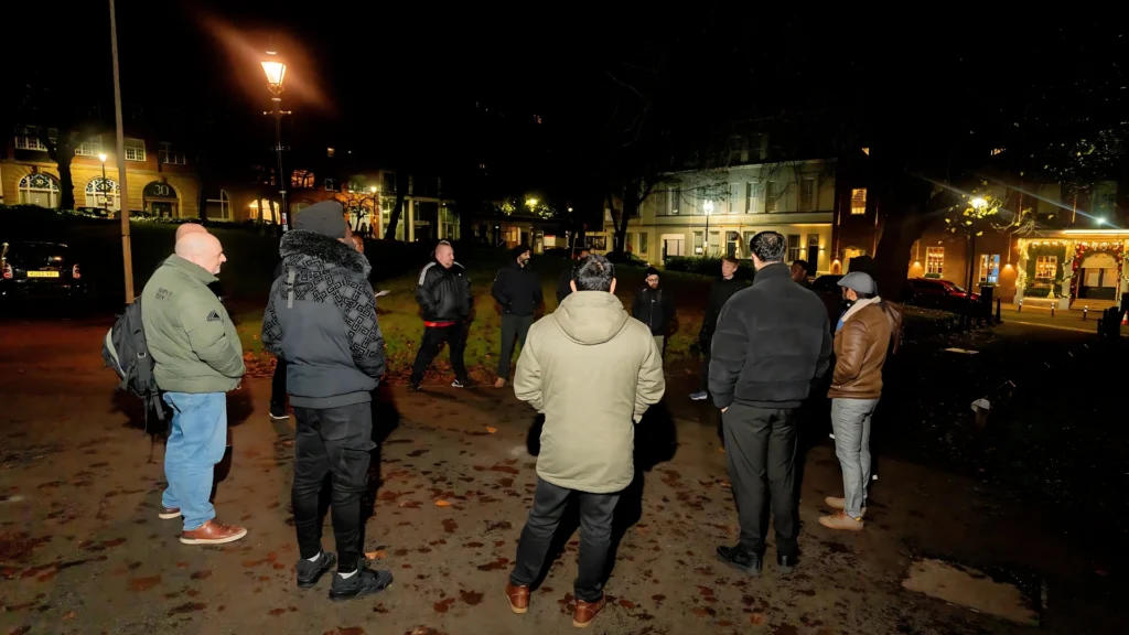 A-group-of-Mens-Prosperity-Club-(MPC)-members-gathered-in-a-circle-at-night-engaging-in-discussion-and-community-building-for-spiritual-growth-and-personal-development