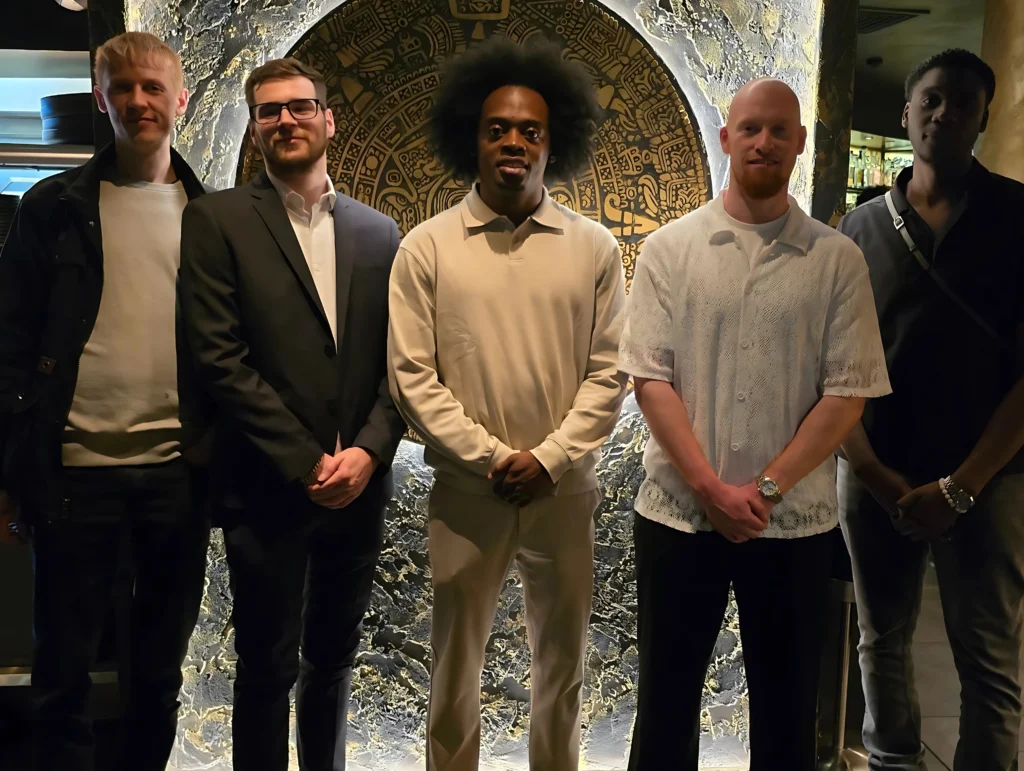 Group-photo-at-MPC-health-and-fitness-event-posing-in-front-of-an-ornate-wall