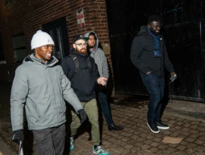A-group-of-four-people-walking-outdoors-during-season-2-session-4-of-MPC