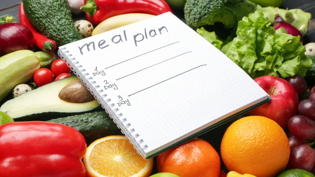 Healthy-Diet-Meal-Plans-notebook-surrounded-by-fresh-vegetables-and-fruits