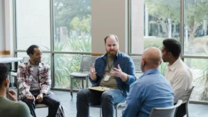 Group-of-people-in-therapy-session-participating-in-a-support-group-with-discussion-about-mental-health-crisis