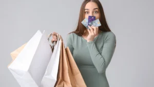 Young-woman-holding-multiple-shopping-bags-and-credit-cards-showing-excitement