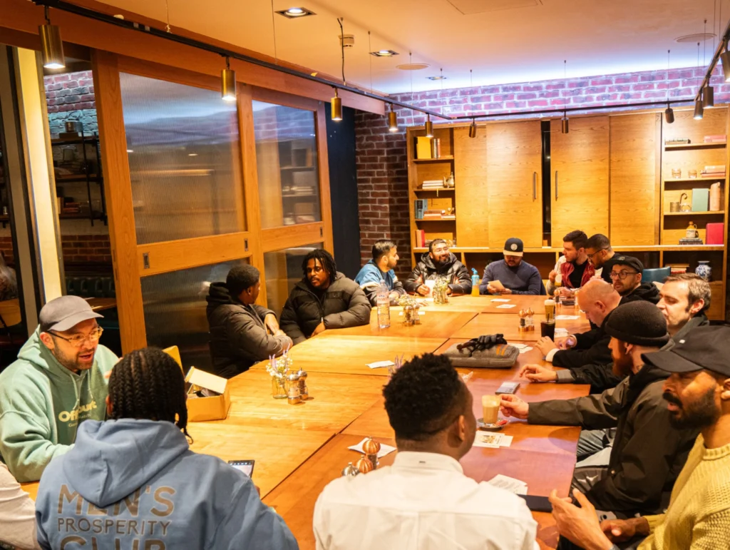 A-group-of-people-gathered-around-a-table-in-a-Health-&-Fitness-club,-engaging-in-a-discussion-1