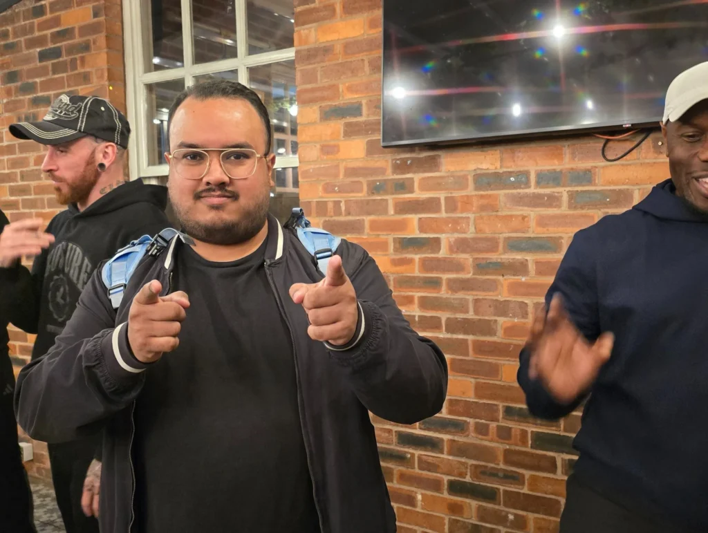 Group-of-people-interacting-at-a-networking-event-with-one-individual-pointing-and-smiling