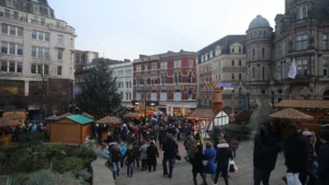 Crowd-at-a-festive-market-during-the-holiday-season-with-Christmas-trees-and-stalls