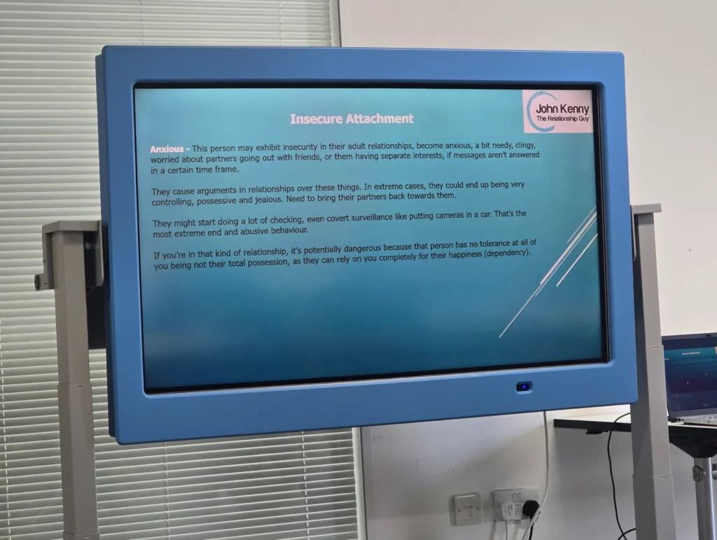 John-Kenny-presenting-at-the-PD-workshop-with-a-focus-on-the-slide-about-insecure-attachment-while-the-audience-listens-attentively