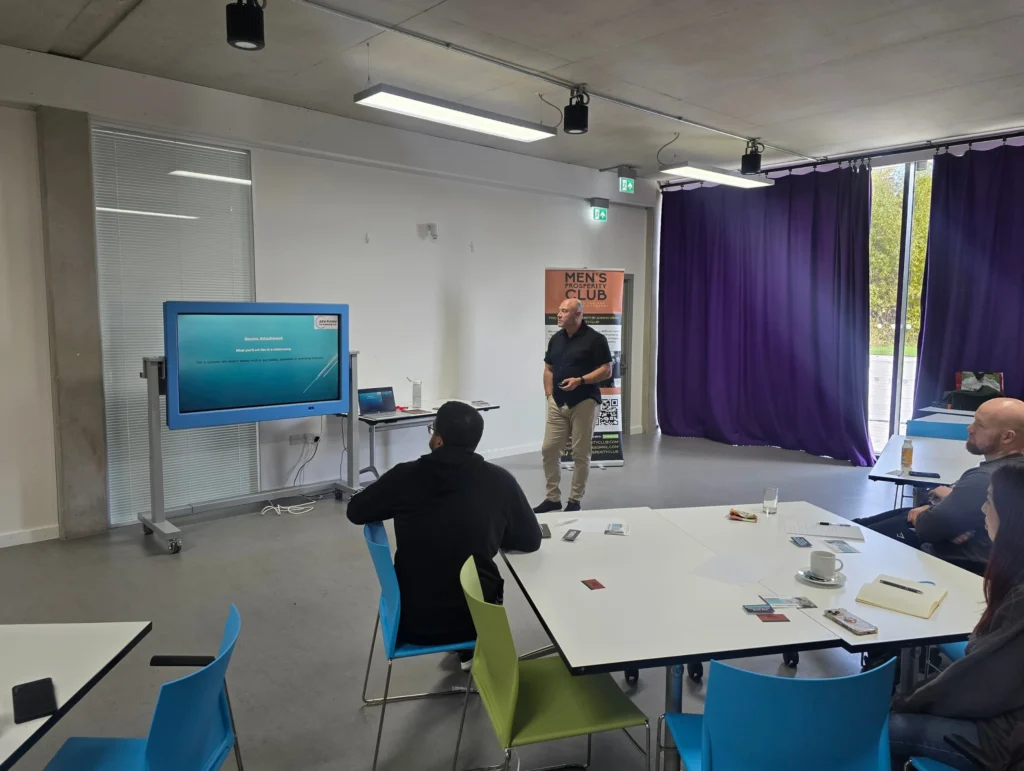 John-Kenny-the-presenter-shaking-hands-with-a-participant-after-the-PD-workshop-with-the-Men's-Prosperity-Club-banner-in-the-background