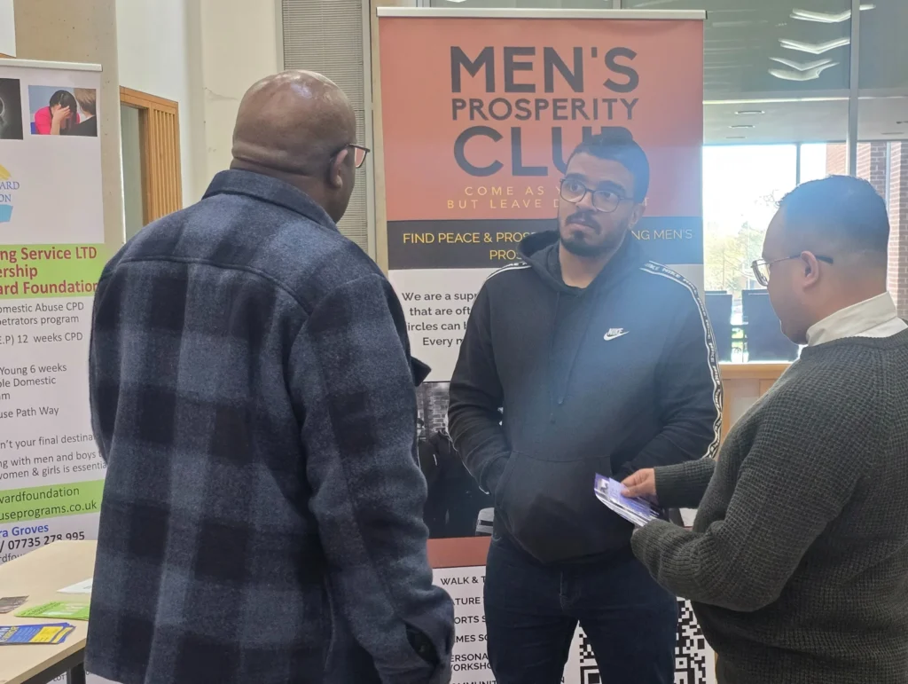 Newman-University-Event-Participant-from-Men's-Prosperity-Club-engaging-with-a-visitor