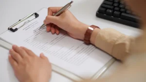 Person-signing-a-financial-document-for-money-management