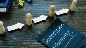 Succession-Planning-with-wooden-pawns-and-arrows-on-dark-table