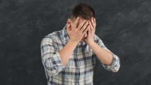 A-man-covering-his-face-with-his-hands-reflecting-emotional-struggle-highlighting-the-significance-of-emotional-expression
